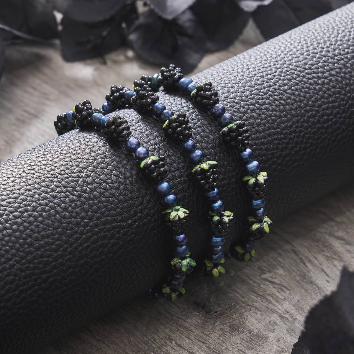 Blue x Midnight Blue Pearl bracelet featuring glossy midnight blue freshwater pearls and black berry beads on textured black display by NOGU